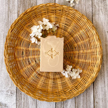 Load image into Gallery viewer, Off-white, tall soap bar with white swirls, a textured top, and a company stamp on the surface.