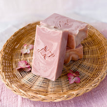 Load image into Gallery viewer, Powdery rose-colored tall soap bar with pale-rose swirls and a wavy textured top. It features a Woods and Mosses company stamp on its surface.