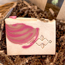 Load image into Gallery viewer, A close-up of a handmade rectangular soap with a vibrant pink swirl design, placed on crinkle paper in a gift box. The soap features the Woods and Mosses logo stamp, adding a decorative touch to the natural, handcrafted product.