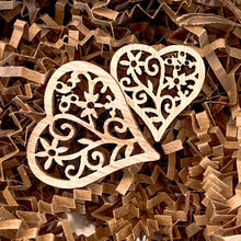Load image into Gallery viewer, A close-up of two wooden heart-shaped decorations with intricate floral cutout designs, placed on crinkle paper. The delicate patterns of the wooden hearts add a handcrafted and rustic touch, perfect for enhancing gift presentations.