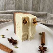 Load image into Gallery viewer, Two upright handmade spiced orange soap bars with layered tones and festive tops featuring dried orange slices and cinnamon sticks, crafted for holiday gifting and seasonal self care.