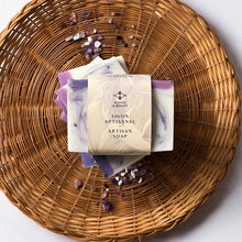 Load image into Gallery viewer, The soap bar is labeled and wrapped with recyclable paper for an eco-friendly touch. The label features the Woods and Mosses logo and the words Artisan Soap in both French and English.