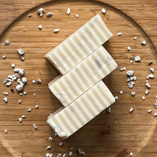 Load image into Gallery viewer, Three artisan soap bars stacked diagonally, each with a smooth marbled surface and textured wave-like sides, displaying a minimalist handcrafted look.