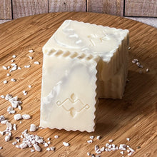 Load image into Gallery viewer, A handcrafted rectangular soap bar with a white and light gray marble swirl pattern, scalloped edges, and an embossed geometric Woods and Mosses logo on the front.