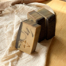 Load image into Gallery viewer, Natural handmade coffee soap bars with dark textured tops and marbled tan bases, featuring an embossed Woods and Mosses logo on the side.