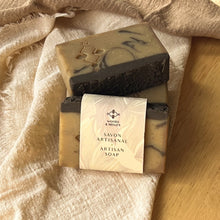 Load image into Gallery viewer, Stacked natural coffee soaps with cream-colored paper label reading Artisan Soap and Woods and Mosses, showing marbled tan and black pattern.