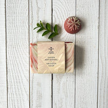 Load image into Gallery viewer, Handcrafted artisan Christmas soap bar wrapped with Woods & Mosses label. The bar shows festive red, cream, and green swirls in a marbled design, resembling peppermint candy. A natural cold process holiday soap packaged for seasonal gifting.