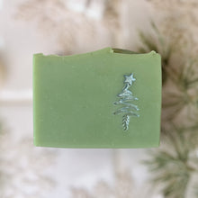 Load image into Gallery viewer, Handcrafted green soap bar featuring a silver Christmas tree with a star design, made with natural ingredients and styled as a festive artisan holiday skincare gift.