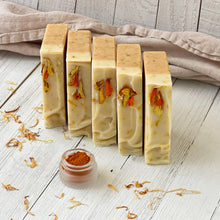Load image into Gallery viewer, Vertical view of standing Calendula & Turmeric soap bars topped with calendula petals. Natural handmade skincare with botanical highlights by Woods and Mosses