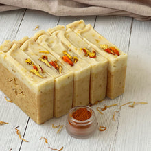 Load image into Gallery viewer, Five Calendula & Turmeric soap bars arranged at an angle on a rustic surface with marigold petals. Natural handcrafted soap for skincare.
