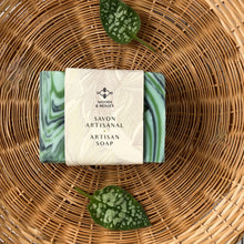 Load image into Gallery viewer, Green swirl artisan soap bar wrapped in a Woods & Mosses label reading 'Savon Artisanal – Artisan Soap,' featuring a botanical design and minimalist branding.