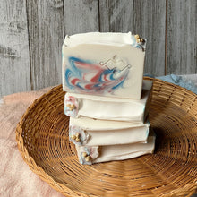 Charger l'image dans la galerie, Stack of handmade jasmine soap bars with pink and blue swirls, floral toppings, and embossed branding, crafted by Woods and Mosses