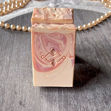 Load image into Gallery viewer, Close-up of swirl soap with embossed top, textured finish, and pearls on a gray round board.