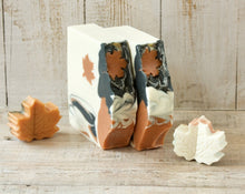 Load image into Gallery viewer, Square soap bar with a wavy top. Design: beige soap with an orange maple leaf and some black-orange waves. The top is orange and black with orange maple leaves and some glitter.