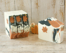 Load image into Gallery viewer, Square soap bar with a wavy top. Design: beige soap with an orange maple leaf and some black-orange waves. The top is orange and black with orange maple leaves and some glitter.