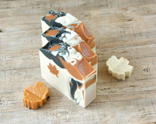 Load image into Gallery viewer, Square soap bar with a wavy top. Design: beige soap with an orange maple leaf and some black-orange waves. The top is orange and black with orange maple leaves and some glitter.