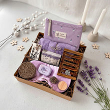 Load image into Gallery viewer, Eco-friendly bath set in kraft box: light purple soap, brown shampoo bar, light purple makeup bag, light purple towel, transparent glass jar, purple tin, white wax sachet. Includes wooden dish and two natural pinecones.
