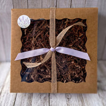 Load image into Gallery viewer, Brown gift box with a window, tied with a lavender ribbon and a round label on a wooden surface.