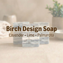 Load image into Gallery viewer, Set of Birch Design soap bars, gray-and-ivory striped pattern; front bar shows embossed logo (Lavender, Lime, Palmarosa).