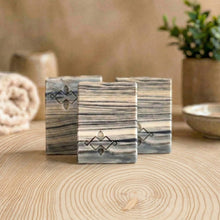 Load image into Gallery viewer, A square soap bar with a birch bark pattern in white, gray, and black, featuring a stamped logo in the corner. Ideal for gifting or as a decorative bathroom accent.