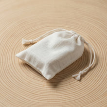Load image into Gallery viewer, The ivory-colored cotton bag is eco-friendly and reusable, featuring drawstrings that make it perfect for packaging soap.
