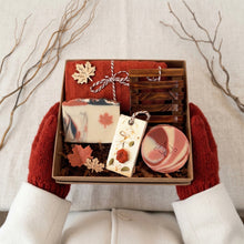 Load image into Gallery viewer, Kraft box with raffia paper, beige maple soap, cranberry round soap, wooden soap dish, red face cloth, botanical wax sachet, leaf-shaped soap, and two wooden leaf accents.