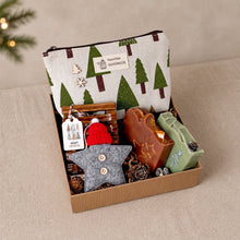 Load image into Gallery viewer, Open Scandinavian Christmas gift box with two handmade soaps, canvas makeup bag, wooden soap dish, felt star ornament, and natural decor.
