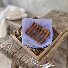 Load image into Gallery viewer, A wooden soap dish with seven bars and a soft purple cotton face cloth.
