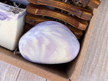 Load image into Gallery viewer, Artisan soap bar mimicking the appearance of a rock, featuring a smooth white surface accented by vibrant purple swirls that emulate natural stone patterns.