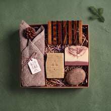 Load image into Gallery viewer, Christmas self-care gift box with handmade soaps, rosemary and mint shampoo bar, cotton face cloth, wooden soap dish and pine cone.