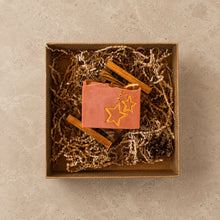 Load image into Gallery viewer, Christmas Eve handmade soap with gold star design, dried orange, cinnamon sticks, and pinecone in a kraft gift box.