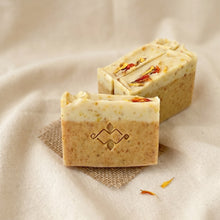 Load image into Gallery viewer, Three calendula turmeric soap bars with creamy layers, speckled texture, and dried flower petals