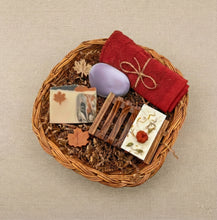 Charger l'image dans la galerie, Canadian self care gift box with handmade natural soaps, wooden soap dish, red towel, and maple leaf decorations arranged in a wicker basket.