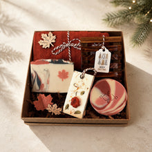 Load image into Gallery viewer, Canadian Christmas gift box with maple leaf soap, cranberry soap, red face cloth, wooden dish, wax sachet and leaf accents.