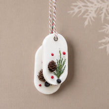 Charger l'image dans la galerie, Two overlapping white soy wax sachets with evergreen sprigs, pinecones, berry accents, and hanging cords