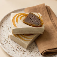 Load image into Gallery viewer, Two stacked autumn soap bars with cream bases, ochre swirls, raised brown tree designs, and handmade edges.