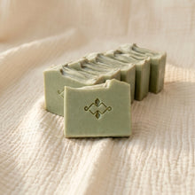 Load image into Gallery viewer, Row of pale green frankincense and orange soap bars on beige fabric