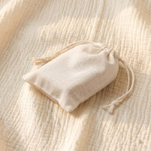 Load image into Gallery viewer, Beige drawstring gift pouch on textured fabric