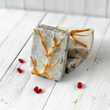 Load image into Gallery viewer, Three rectangular artisan soaps with a frosted white base and embedded natural speckles, decorated with golden branch-like accents on the surface, creating an elegant festive design.