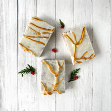 Load image into Gallery viewer, Three rectangular artisan soaps with a frosted white base and embedded natural speckles, decorated with golden branch-like accents on the surface, creating an elegant festive design.