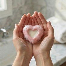 Load image into Gallery viewer, Pink heart-shaped handmade soap with white center and light lather, shown in hands as a gentle cleansing bar