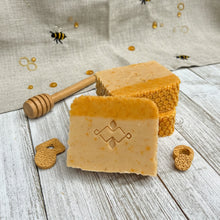 Load image into Gallery viewer, Square soap bar, two-toned yellow with a Woods and Mosses logo. Features tiny honey dots and a textured honeycomb design on top.