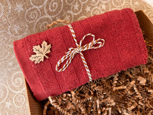 Load image into Gallery viewer, Canadian Christmas Self Care Gift Box featuring red cotton towel tied with decorative rope by Woods and Mosses.