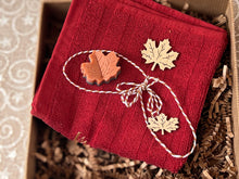 Load image into Gallery viewer, Canadian Christmas Self Care Gift Box featuring red facial towel and maple leaf shaped small decor by Woods and Mosses.