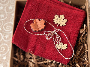 Canadian Christmas Self Care Gift Box featuring red facial towel and maple leaf shaped small decor by Woods and Mosses.