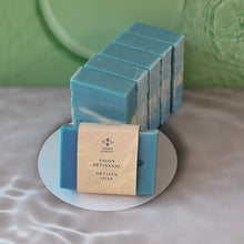 Load image into Gallery viewer, The soap bar is labeled and wrapped with recyclable paper for an eco-friendly touch. The label features the Woods and Mosses company logo and the words Artisan Soap in both French and English.