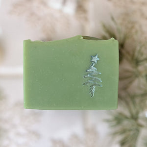 A pale green square soap with a handpainted silver Christmas tree. The bar has a wavy top.