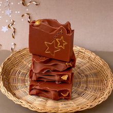 Load image into Gallery viewer, A red-brownish square soap with handpainted golden stars. The bar has a wavy top decorated with an orange slice.