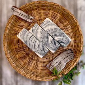 A square soap bar with a birch bark pattern in white, gray, and black.