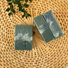 Load image into Gallery viewer, Square soap bars in dark and light sage green, with grey and white swirls and a stamped Woods and Mosses company logo on the surface.